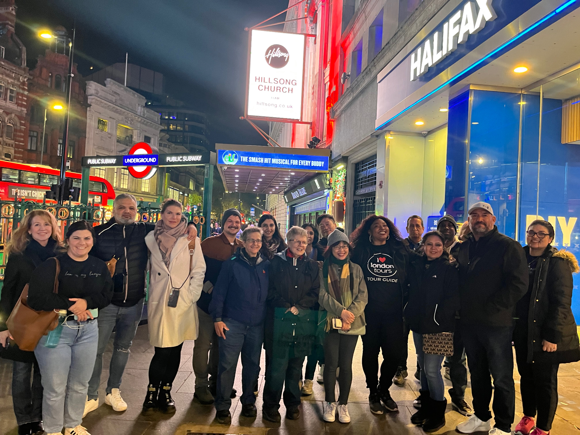 Evening tour group at illuminated Piccadilly Circus during London nightlife tour