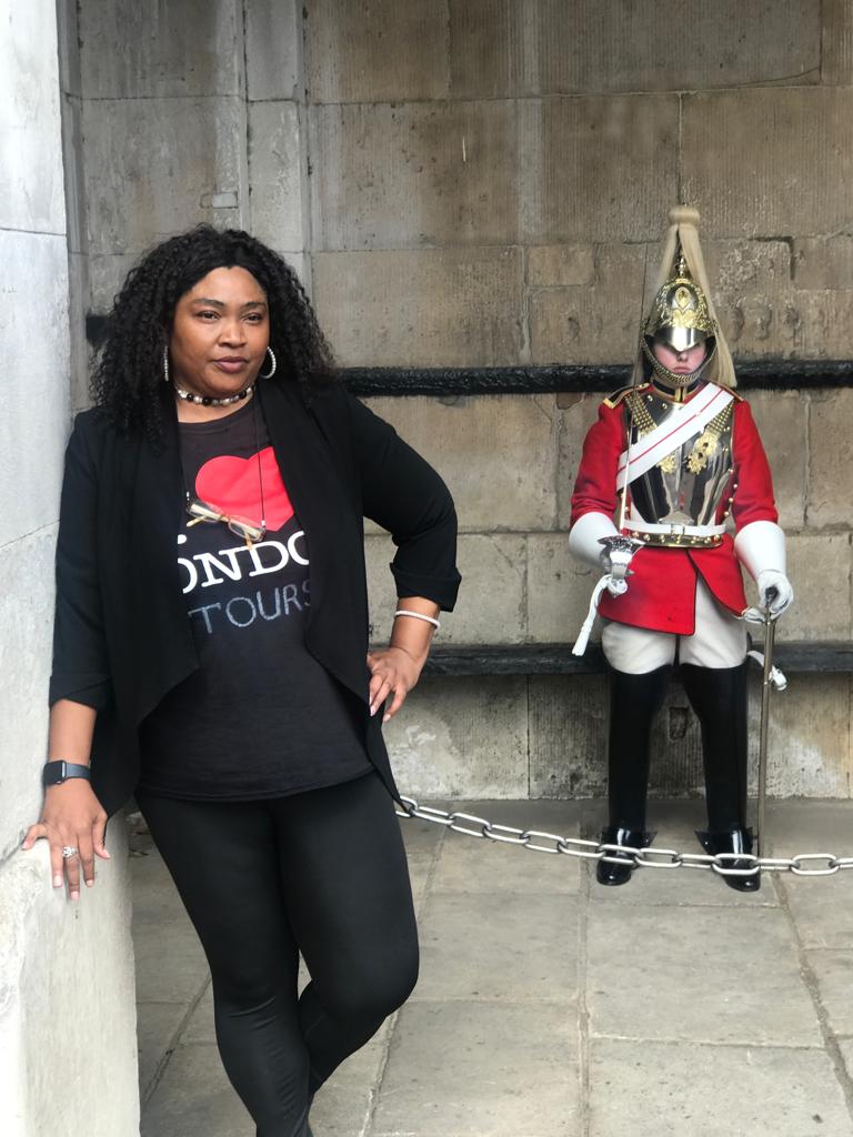 Tour guide posing with Royal Guard at Buckingham Palace during London landmarks tour